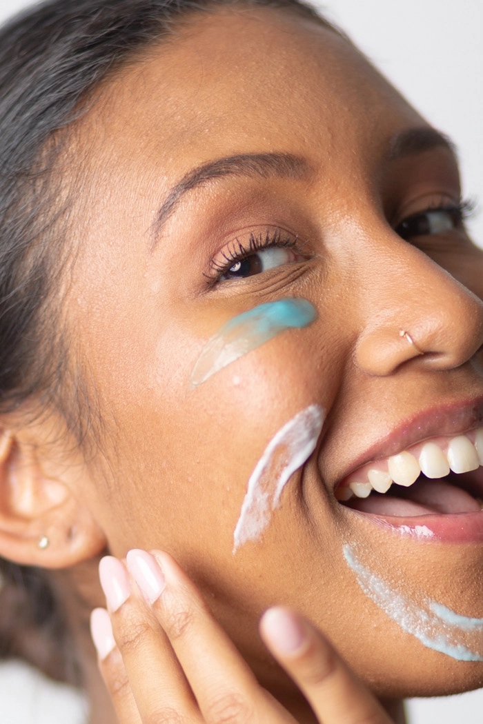 Smiling person with skincare products